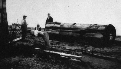 Old Clallam Indian at Jamestown making a canoe from a large cedar log.